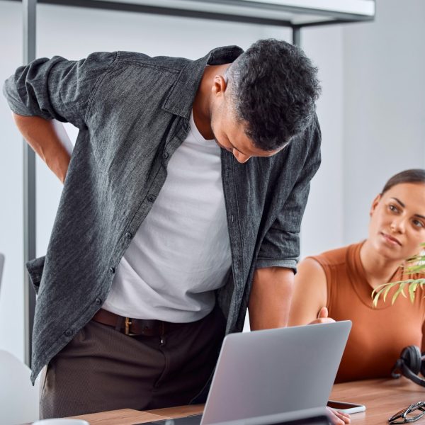 Back pain is so unbearable. Shot of a young businessman in pain in an office.